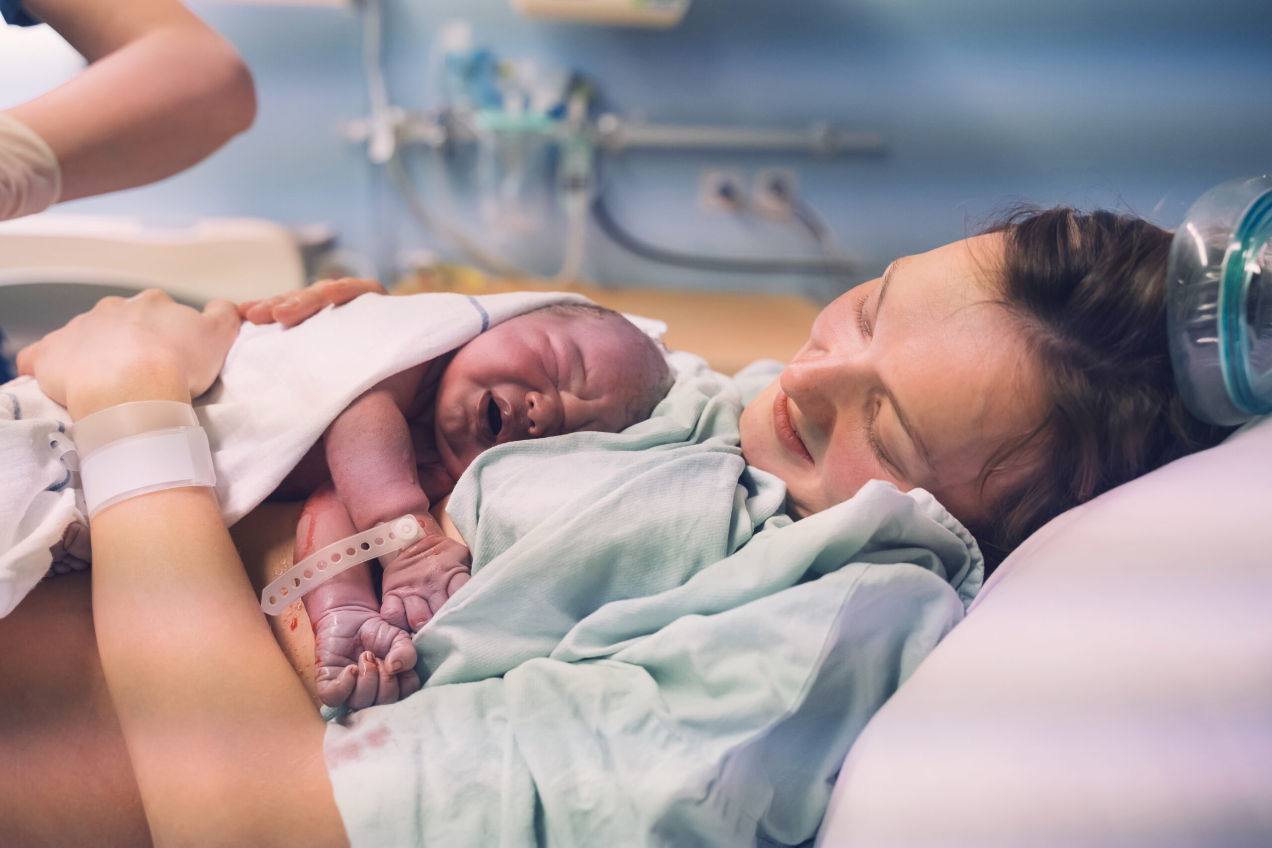 White mother and newborn. Child birth in maternity hospital.