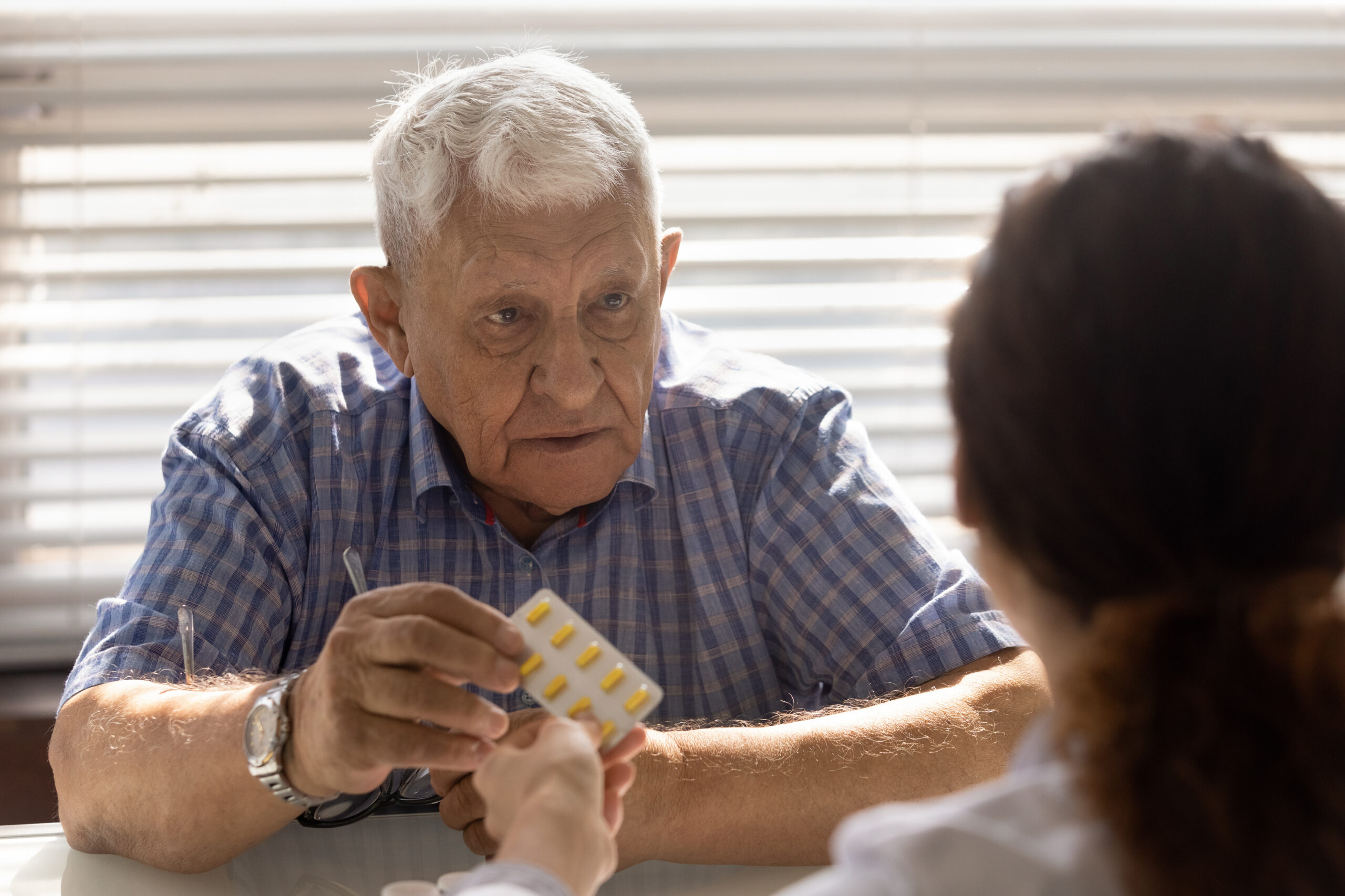 Senior Caucasian male patient consult with doctor about medication pills prescription. Old mature man client get medicines from GP at consultation in hospital. Healthcare, elderly medicine concept.